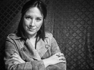 A black and white photo of a woman with her arms crossed